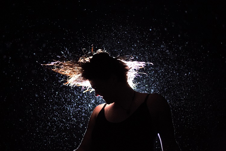 Woman shaking energetically stress and tension off her body and mind
